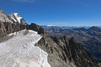 Scenic view of snowcapped mountains against clear blue sky