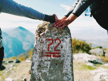 Couples holding hands on kilometer stone