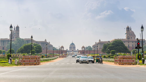 Traffic on road in city against sky