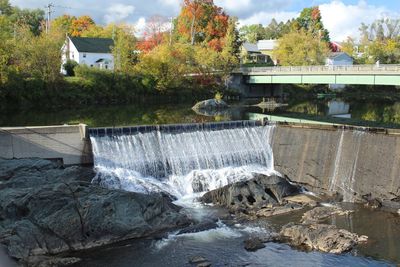 View of dam by river against sky