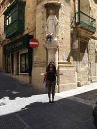 Full length of woman standing against building in city