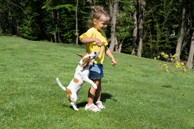 Woman playing with dog on field