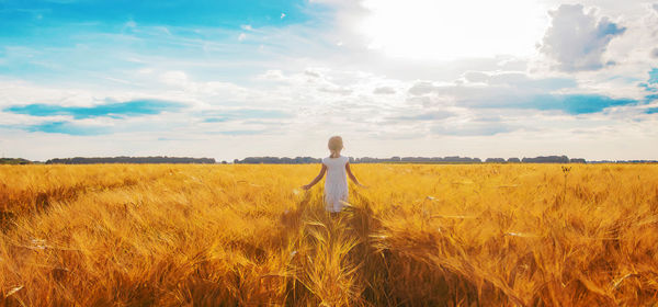 Woman standing on field against sky