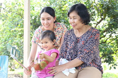 Portrait of mother and daughter sitting outdoors