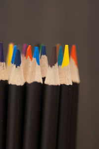 Close-up of colored pencils over black background