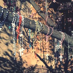 Rosary beads hanging on tree against wall