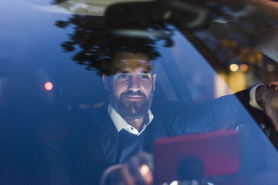 Businessman using navigation device in car at night