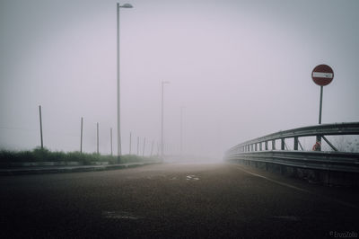 Road by bridge against sky in city