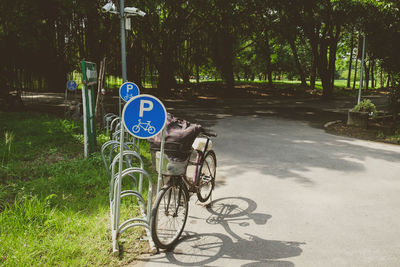 Bicycle sign on road by trees