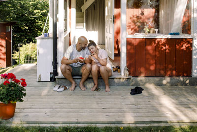 Father talking to daughter while eating watermelon outdoors