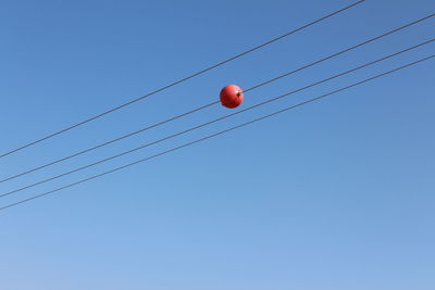 Low angle view of cables against clear blue sky