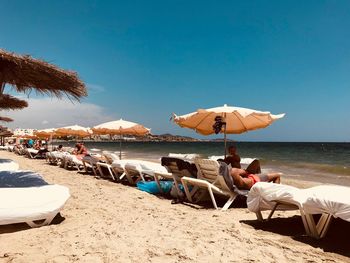 People at beach against sky