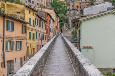 Footpath amidst buildings in city