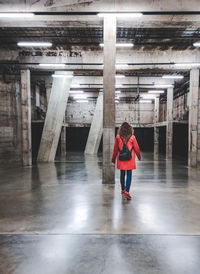 Rear view of woman standing on floor in building