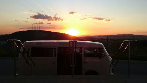 Camper trailer against sky during sunset