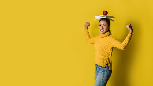 Portrait of smiling man standing against yellow background