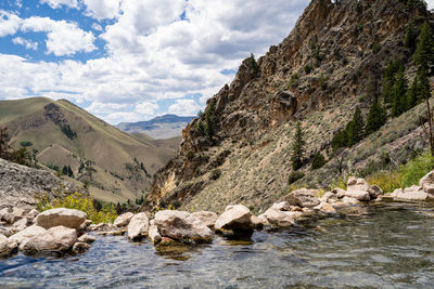 Scenic view of river by mountains against sky