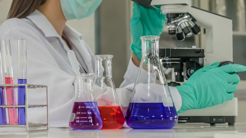 Midsection of scientist working in laboratory