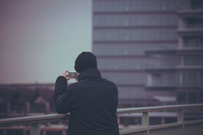 Rear view of woman standing in front of building