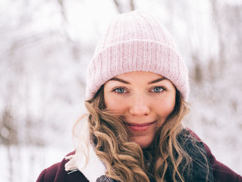 Close-up portrait of young woman wearing knit hat 