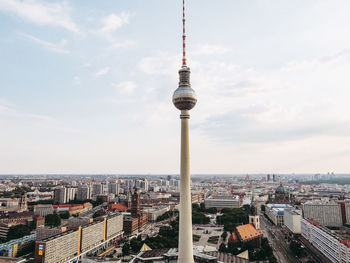 Aerial view of city buildings against cloudy sky