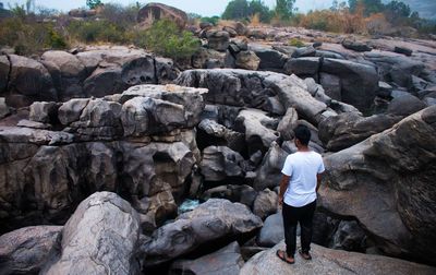 Rear view of man standing on rock