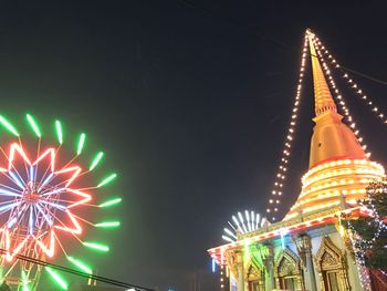 Low angle view of illuminated ferris wheel against sky