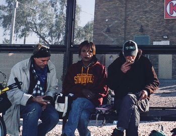 People sitting against wall