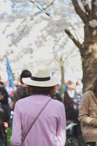 Rear view of man standing by tree in city