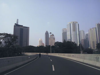 Road amidst buildings against sky in city