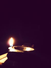 Close-up of lit candle in dark room