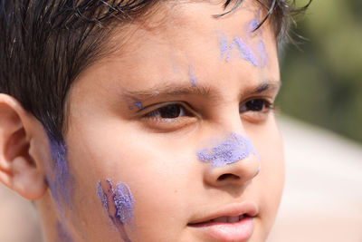 Close-up of boy with powder paint on face during holi