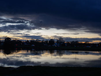 Scenic view of lake against sky at sunset