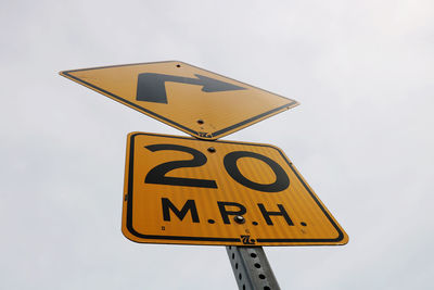 Low angle view of road sign against sky