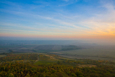 Scenic view of agricultural field against sky during sunset