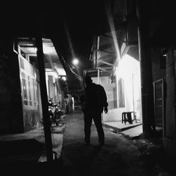 Woman walking in illuminated city at night