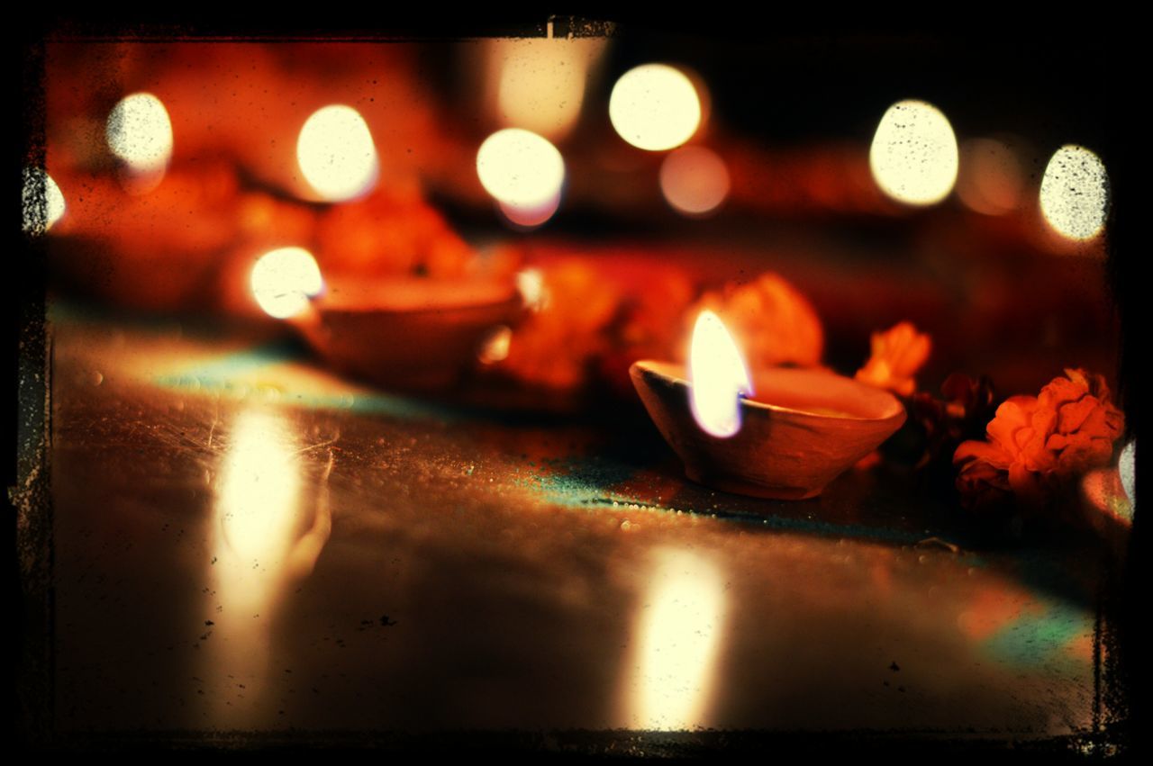 illuminated, indoors, flame, transfer print, glowing, burning, night, close-up, auto post production filter, candle, heat - temperature, reflection, no people, fire - natural phenomenon, light - natural phenomenon, selective focus, orange color, lit, dark, focus on foreground