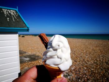Midsection of person holding umbrella against clear sky