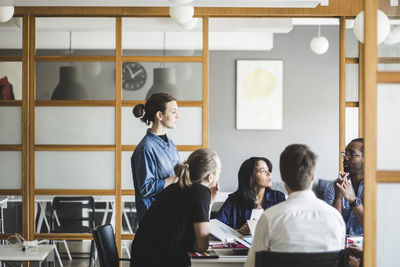 Male and female colleagues planning business strategy in meeting at creative office