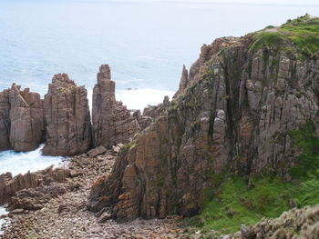 Scenic view of sea by cliff against sky