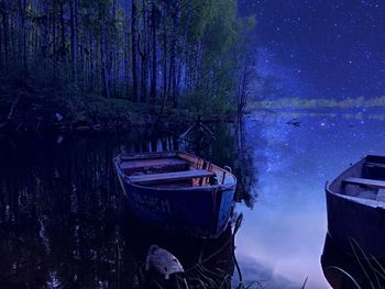 Fishing boats moored on lake at night