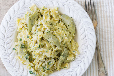 A plate with pasta and artichokes from above.