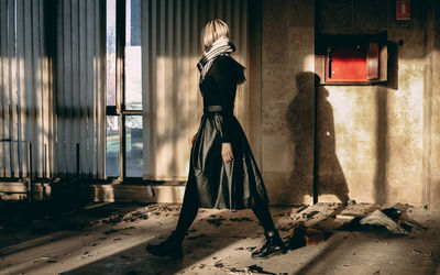 Rear view of woman standing in abandoned room