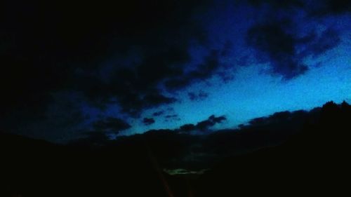 Low angle view of silhouette blue sky at night