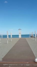 View of beach against clear blue sky