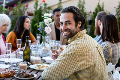 Portrait of smiling friends sitting at restaurant