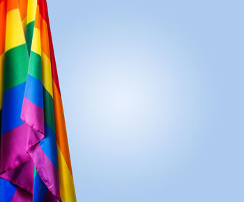 Low angle view of multi colored flag against blue sky