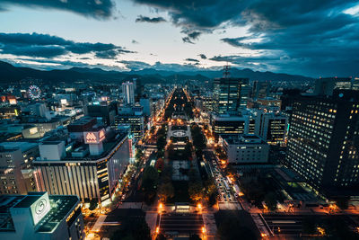 High angle view of illuminated city against sky at dusk