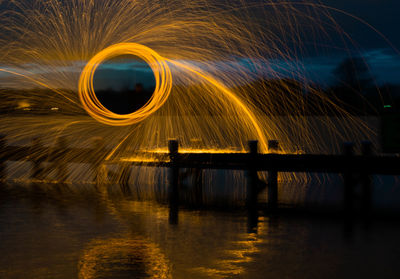 Light painting by lake against sky at night