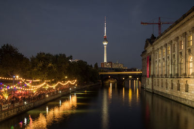 Illuminated bridge over river at night